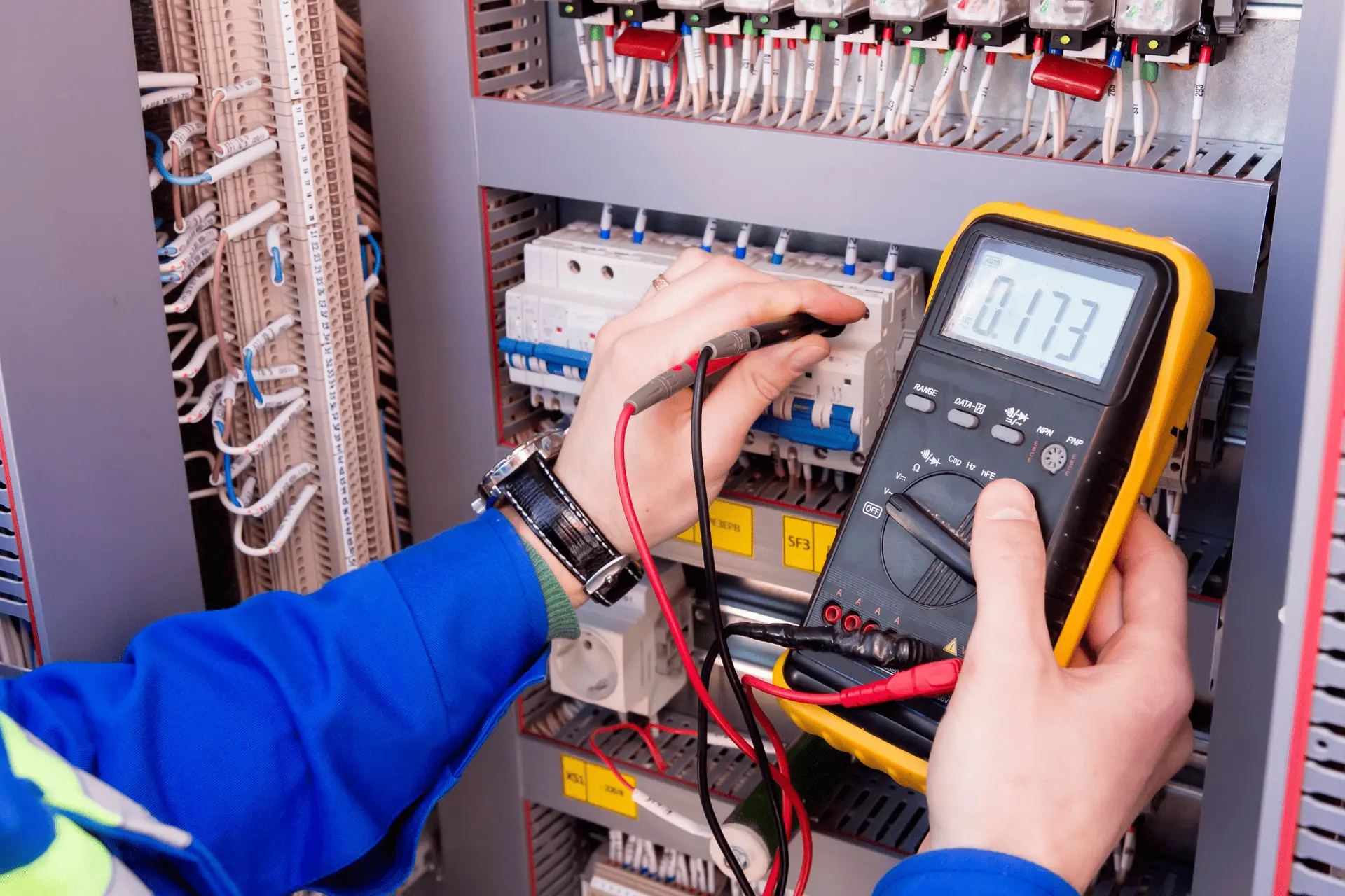 Électricien vérifiant un panneau électrique avec un multimètre